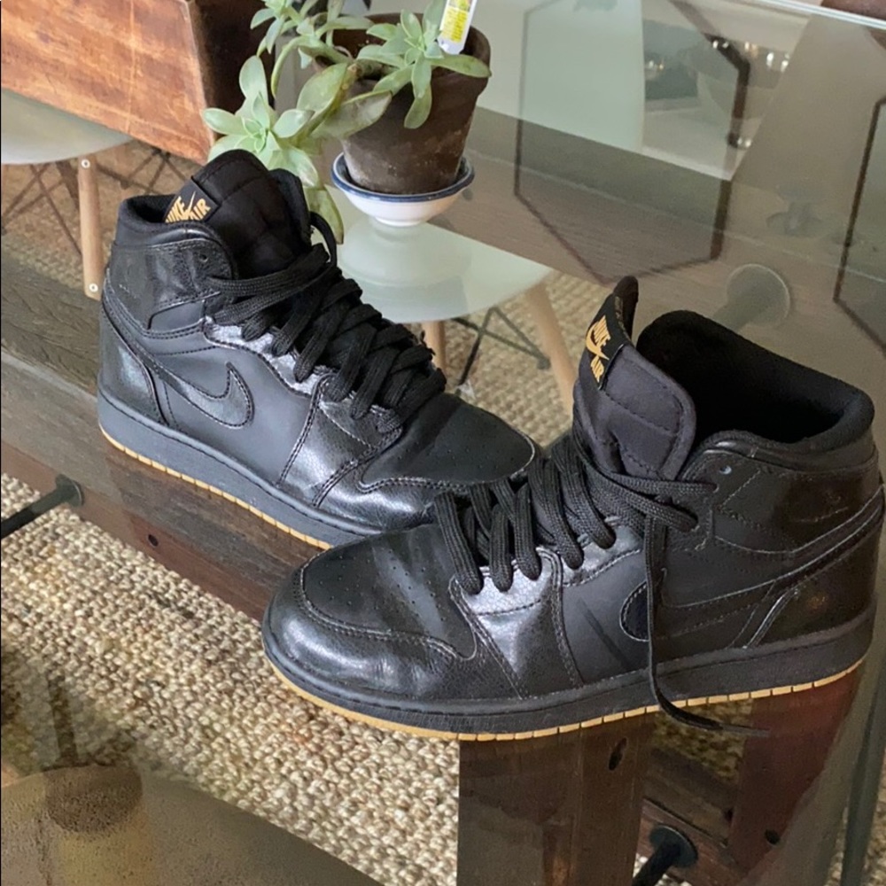 All black with gum sole Nike Jordan 1s